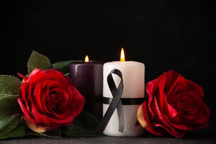 front-view-of-pair-of-candles-red-flowers-on-black Międzynarodowy transport pogrzebowy